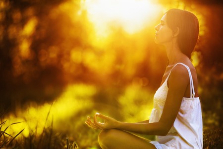 43960890 - yoga woman meditating at sunset. female model meditating in serene harmony