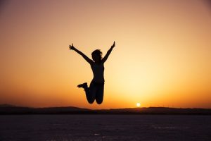 37046532 - silhouette of happy woman jumping in sunset