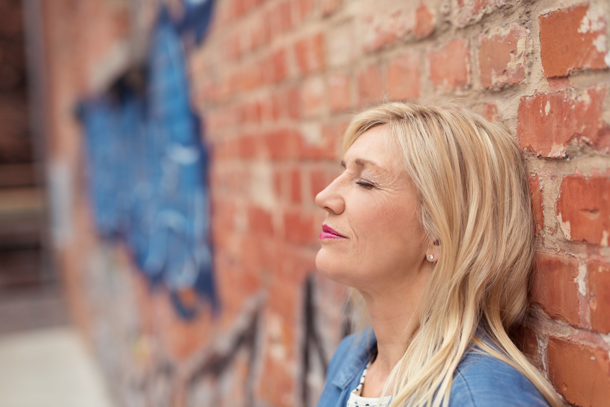 Woman relaxing against a wall